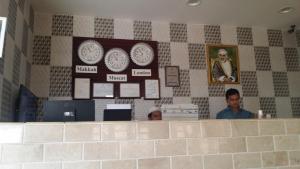 twee mannen aan een balie in een restaurant bij Alafeeh Corniche Hotel Apartments in Sur