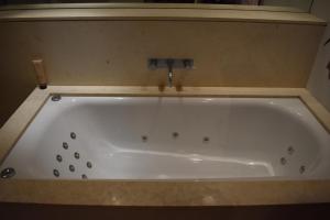 a bath tub with a faucet in a bathroom at CBD Heritage King Suite - Spa Bath, Private Deck and Laundry in Sydney +4 photos