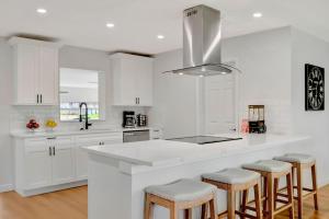 a white kitchen with white cabinets and bar stools at Oyster House Waterfront 3b2b Kayaks BBQ Games in Hernando Beach