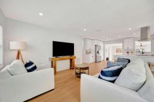 a living room with two white couches and a tv at Oyster House Waterfront 3b2b Kayaks BBQ Games in Hernando Beach