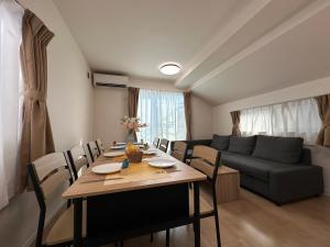 a living room with a table and a couch at nestay villa tokyo itabashi in Tokyo