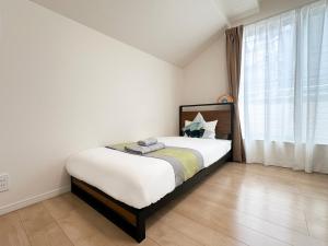 a bedroom with a bed and a large window at nestay villa tokyo itabashi in Tokyo