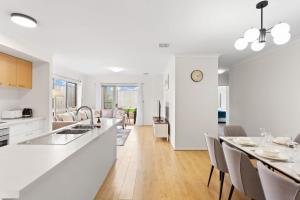 Una cocina y una sala de estar con mesa y sillas. en Modern Family Home sleeps 8, en Wimbledon Heights