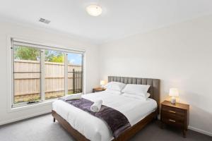 Un dormitorio con una cama y una ventana grande. en Modern Family Home sleeps 8, en Wimbledon Heights