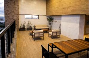 a balcony with tables and chairs and a couch at Incrível Apto 2 quartos próx Consulado Americano in Recife