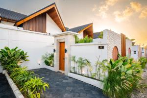 une maison aux murs blancs et aux plantes dans l'établissement Arkarhea Villa, BRAND NEW! 2BR Tropical Villa with Pool, Canggu, à Dalung