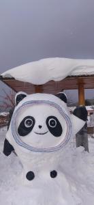 een knuffelpanda kussen in de sneeuw bij Snow Town Jingbei Hotel Erlanghe Scenic Area Branch in Yushu
