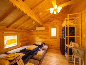 a log cabin bedroom with a bunk bed and a ladder at メロディーハウス 一棟貸新築ログハウス 広いデッキと庭 無垢材の香 小川のせせらぎ in Nasu