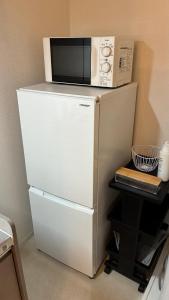 un microondas sobre una nevera en MinatomachiBase1, en Osaka