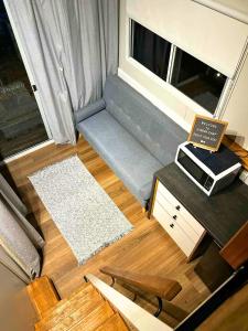 a small living room with a couch and a table at Hidden Camp's Loft House by Tiny Away in Kanighan