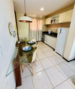 a kitchen with a table and chairs and a refrigerator at Belo apartamento no Solar Pipa in Pipa