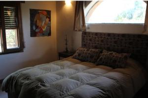 un grand lit dans une chambre avec une grande fenêtre dans l'établissement Cabañas Bendita Tierra, à Los Molles