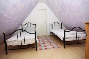 Dos camas en una habitación con paredes moradas. en Ferienhaus in Neukirchen nahe Strand, en Neukirchen