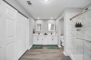 a white bathroom with a shower and a toilet at Cozy 3-bedroom bungalow in Richmond, TX in Richmond +56 photos