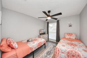 a bedroom with two beds and a ceiling fan at Cozy 3-bedroom bungalow in Richmond, TX in Richmond