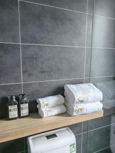 a bathroom with a shelf with towels and a toilet at Jingbei Hotel Erlanghe Scenic Area Branch in Yushu