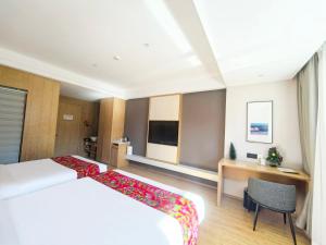 a hotel room with a large bed and a desk at Jingbei Hotel Erlanghe Scenic Area Branch in Yushu