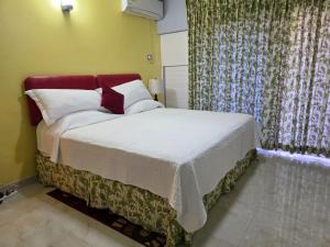 a bedroom with a bed with white sheets and pillows at Harmony Studio - Chrisanns Beach Resort Apt 18 in Ocho Rios +8 photos