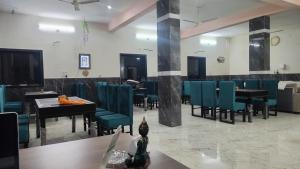 een eetkamer met blauwe stoelen en tafels bij Hotel kamal hans palace in Udaipur