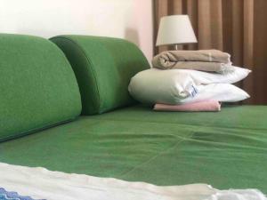 a green bed with a pile of pillows on it at Playa Troya Apartamento a la playa in Playa de las Americas