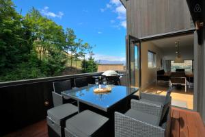 a patio with a table and chairs on a balcony at Birch Haven Spa and Views in Queenstown