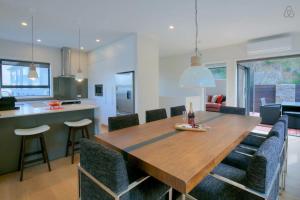 a dining room and kitchen with a wooden table and chairs at Birch Haven Spa and Views in Queenstown