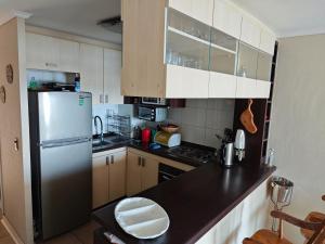 バルパライソにあるConcon vista al mar en Costa Lilenes hasta 6 personasのキッチン(黒いカウンタートップ、冷蔵庫付)