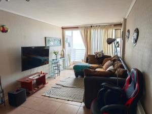 バルパライソにあるConcon vista al mar en Costa Lilenes hasta 6 personasのソファと薄型テレビのあるリビングルーム