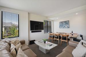 een woonkamer met een bank en een tafel bij Remarkable Lake View in Queenstown +22 foto's