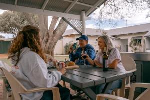 a group of people sitting at a table drinking wine at Busselton Jetty Chalets in Busselton
