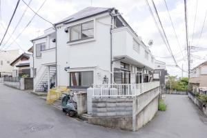 una casa blanca al costado de una calle en Good Place House, en Kawagoe