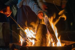 una persona está cocinando comida sobre un fuego en TID TID Yamanakako, en Yamanakako