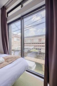 Un dormitorio con una gran ventana con vistas. en Good Place House, en Kawagoe