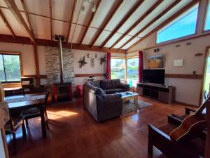 a living room with a couch and a television at Ribera Calle Calle in Valdivia +7 photos