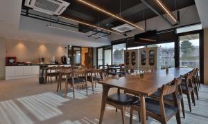 a dining room with tables and chairs and a kitchen at Daegu Billion Western Hotel in Daegu