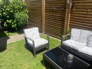 two chairs and a coffee table in a yard at Cocon douillet entre Mer et Montagne in Basse-Terre