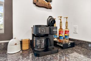 a coffee maker on a counter with bottles of alcohol at NEW! Hot Tub! King Beds! Games! Firepit! EV Charger in Sevierville
