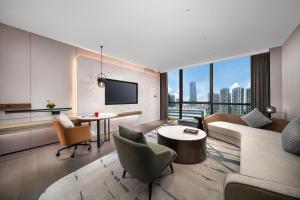 una sala de estar con un sofá y una mesa en Wyndham Grand Shenzhen Guangming, en Shenzhen