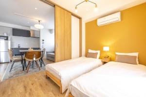 Duas camas num quarto com uma mesa e uma cozinha em GrandTree Hotel - Specutaclor Skytree view! em Tóquio