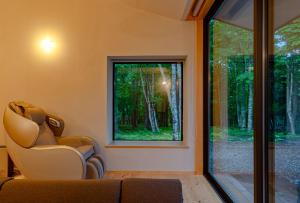 Una sala de estar con un sofá y una ventana. en TID TID Yamanakako, en Yamanakako