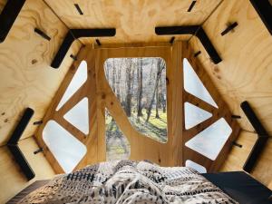a bedroom in a tree house with a large window at Surí refugios Villa O'Higgins, Fin de la Carretera Austral in Villa O'Higgins