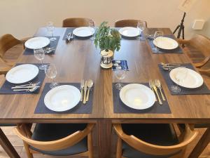 a wooden table with plates and wine glasses on it at TID TID Yamanakako in Yamanakako +94 photos