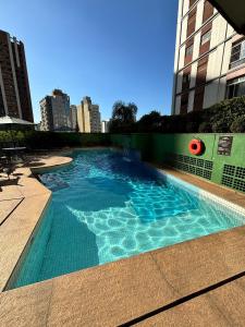 a swimming pool with blue water in a building at Hotel Jardins Univer Pamplona com garage coz 2709 in Sao Paulo