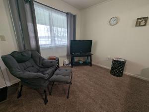 a living room with a chair and a television at Fife Lake Lodge Multi-Level Lake View King Suite in Fife Lake
