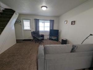 a living room with a couch and a chair at Fife Lake Lodge Multi-Level Lake View King Suite in Fife Lake