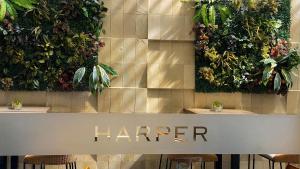 a counter with chairs and plants on a wall at Harper Wahid Hasyim Medan by ASTON in Medan