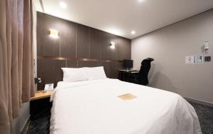 a bedroom with a large white bed and a desk at On & Off Hotel in Incheon