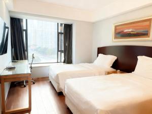 Una habitación de hotel con dos camas, un escritorio y una ventana. en 广州丹顿行政公寓珠江新城店-广交会期间免费穿梭巴士, en Guangzhou 40 fotos más