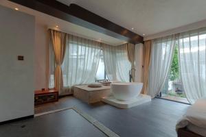 een badkamer met een groot bad in een kamer met ramen bij 大理古城归渊民宿 in Dali (oude stad) +78 foto's