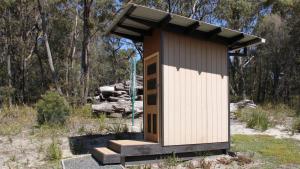 Binalong BayにあるBAY OF FIRES ECO HUT off grid experience at Binalong Bayの森の中にある階段付きの小さな離れ